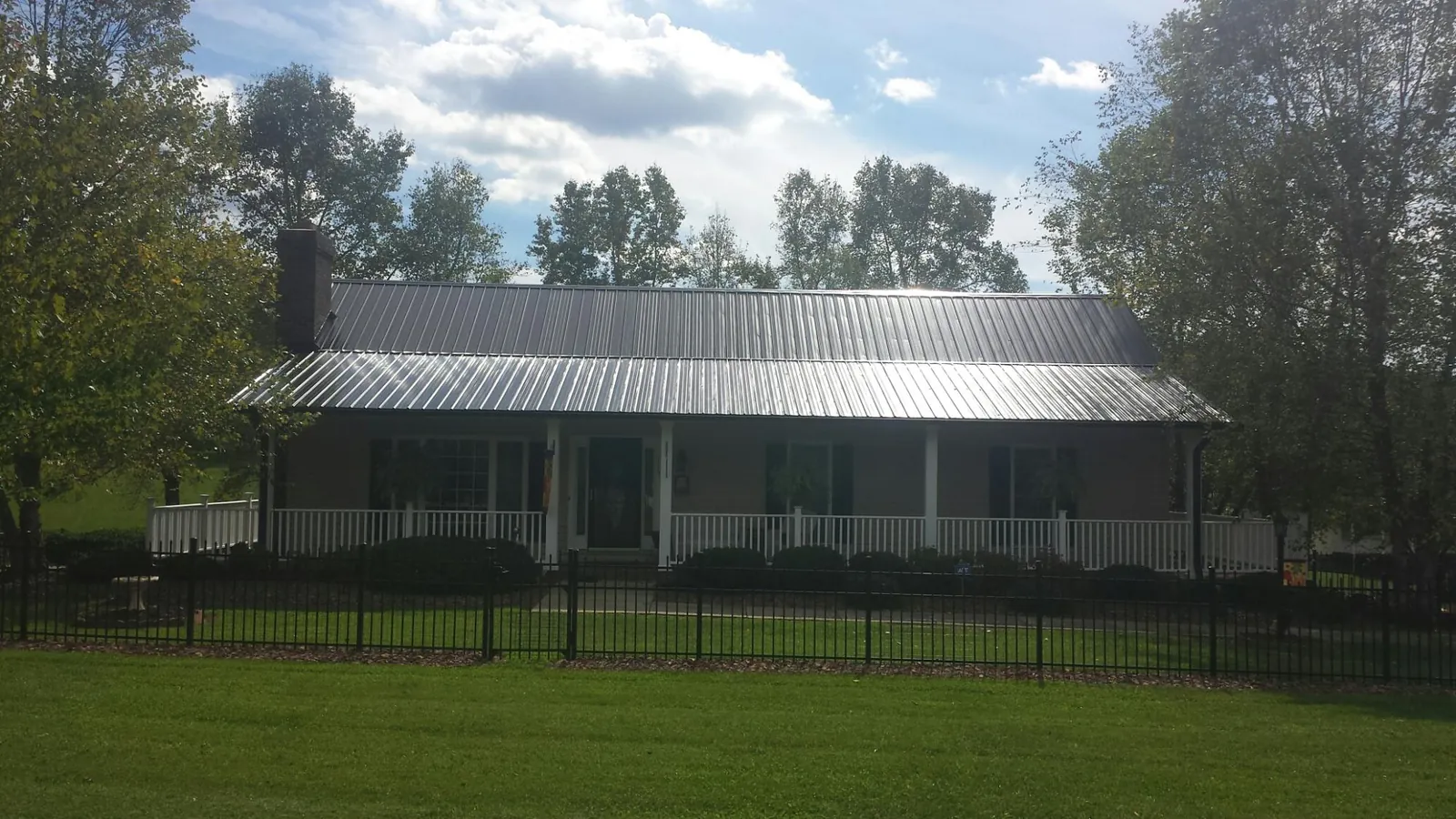 Gray metal roof on a brick ranch with a full width front porch — Gutter Guard Installation work by our crew in Mira Loma