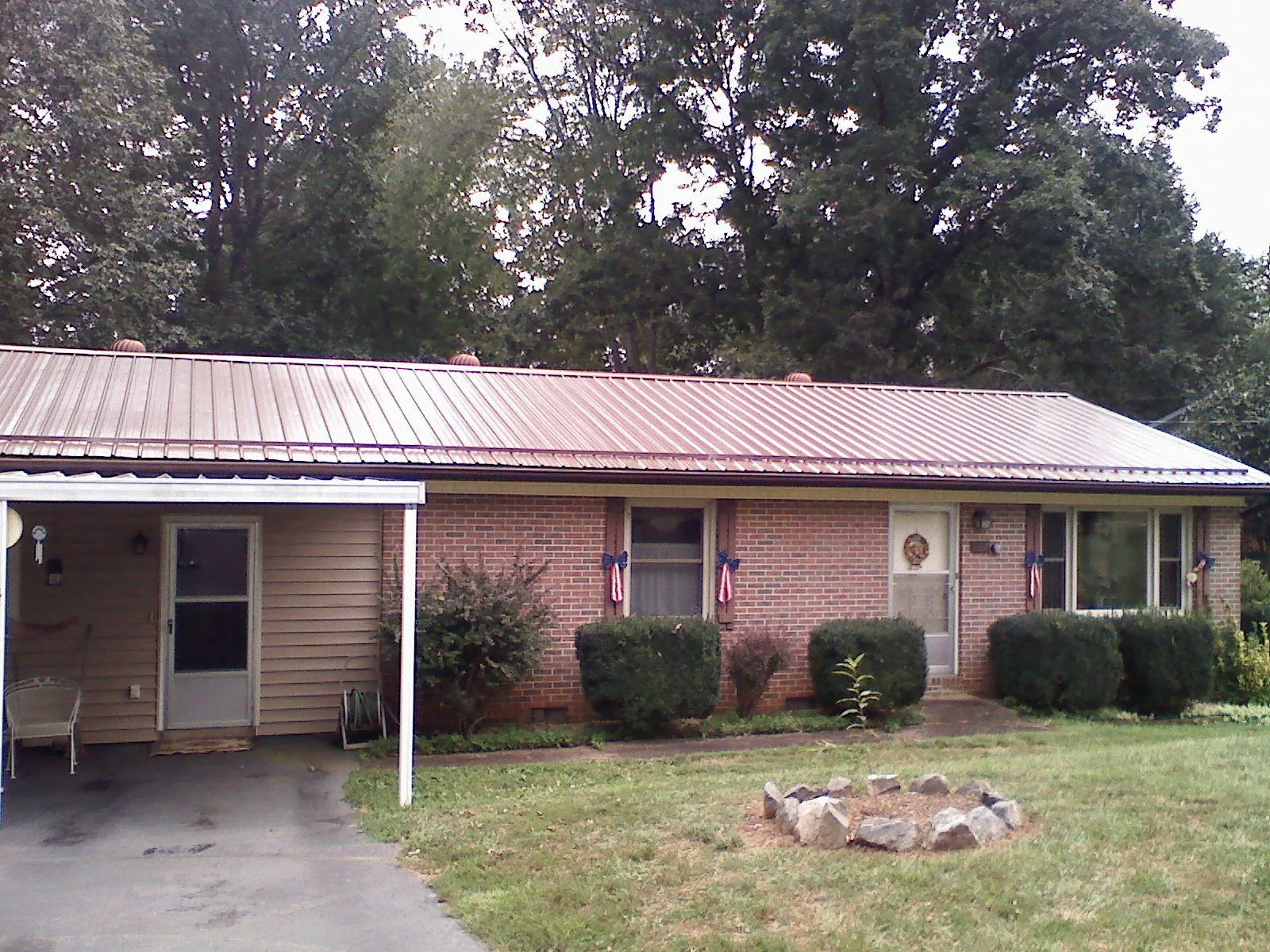Bronze metal roof and carport on a brick ranch home — Roof Repair work by our crew in Mira Loma