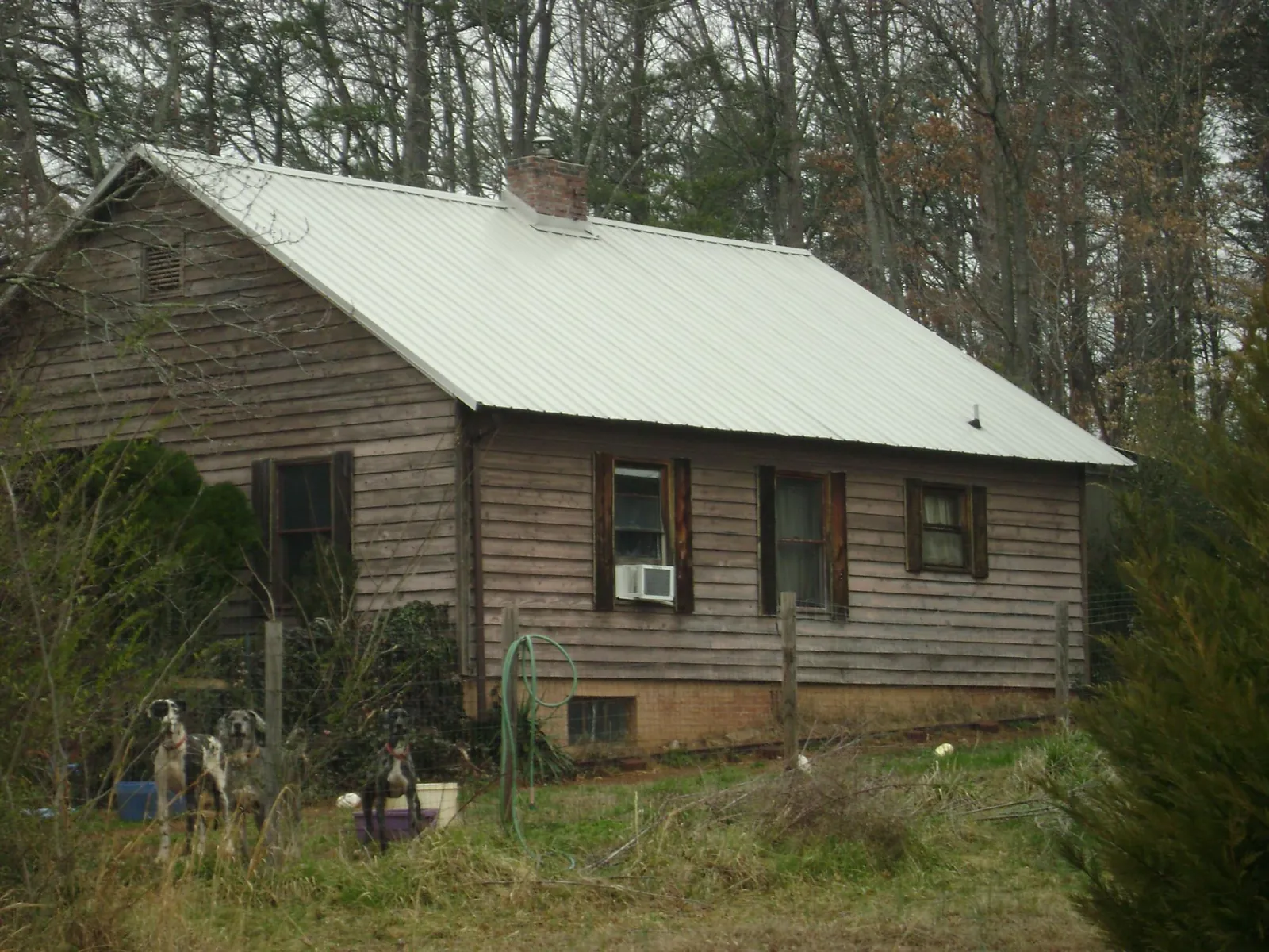 White metal roof on an old wood sided farmhouse, from a Metal Roof Installation job in Mira Loma